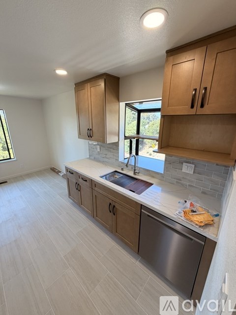 A kitchen with wooden cabinets and a stainless steel dishwasher.
