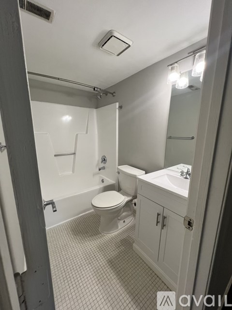 A bathroom with a toilet, sink, and mirror.