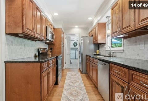 A kitchen with wooden cabinets and a rug on the floor.