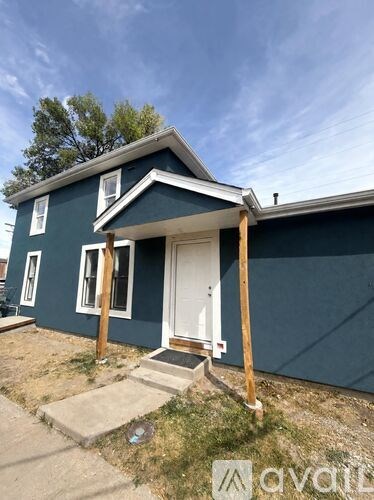 A blue house with a white door and a small porch.