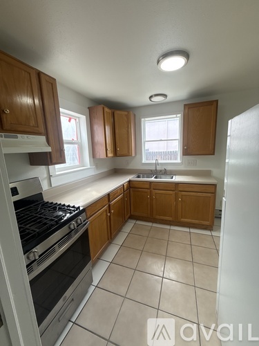 A kitchen with wooden cabinets and a stove top oven.