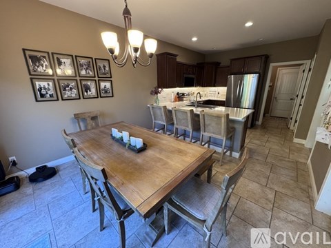 A dining room with a wooden table and chairs.