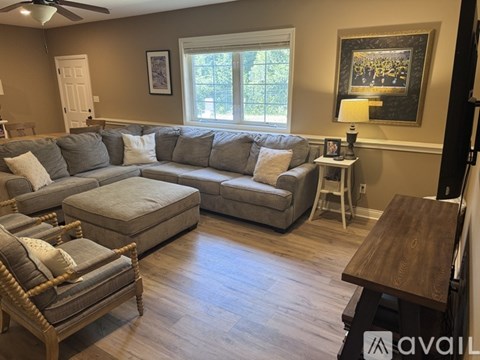 A living room with a grey couch and a wooden table.
