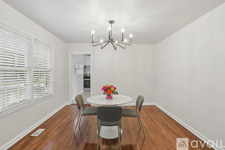 A dining room with a round table and chairs.