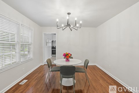 A dining room with a round table and chairs.