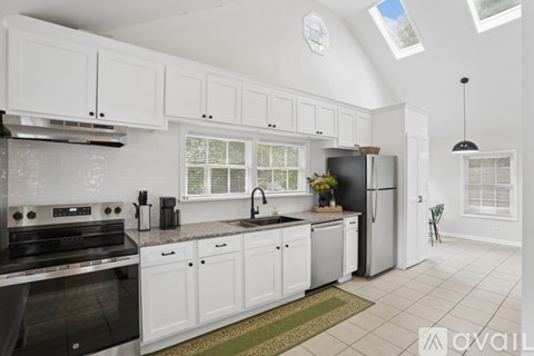 A kitchen with white cabinets and a black stove top oven.