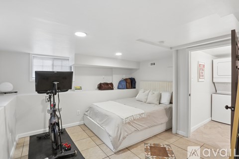 A bedroom with a bed, a bicycle, and a TV.