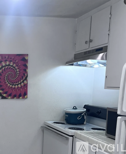 A kitchen with a stove and a pot on it.