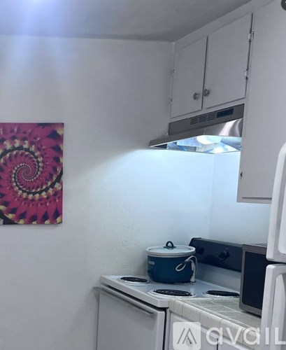 A kitchen with a stove and a pot on it.