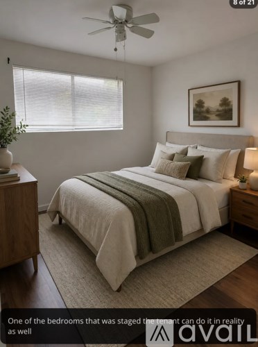 A bedroom with a bed, nightstand, and a ceiling fan.