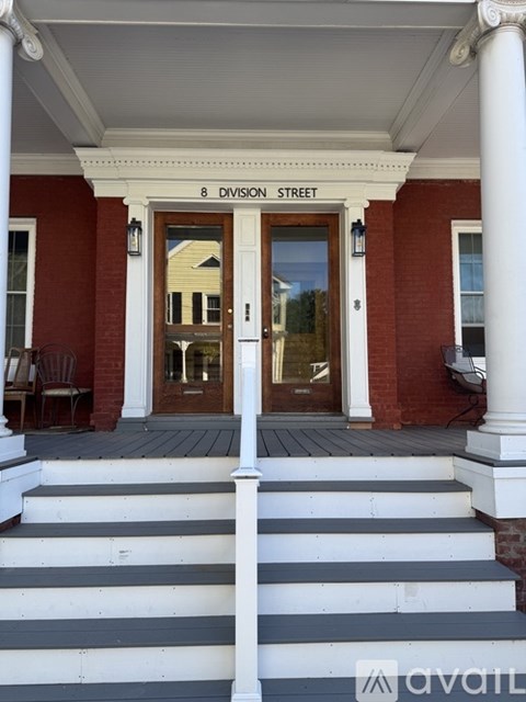 The front steps of a building with a sign that says "8 Division Street".
