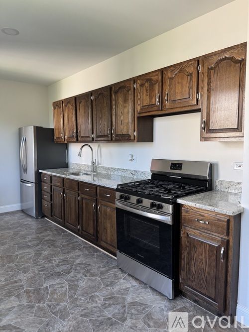 A kitchen with wooden cabinets and a black stove top oven.