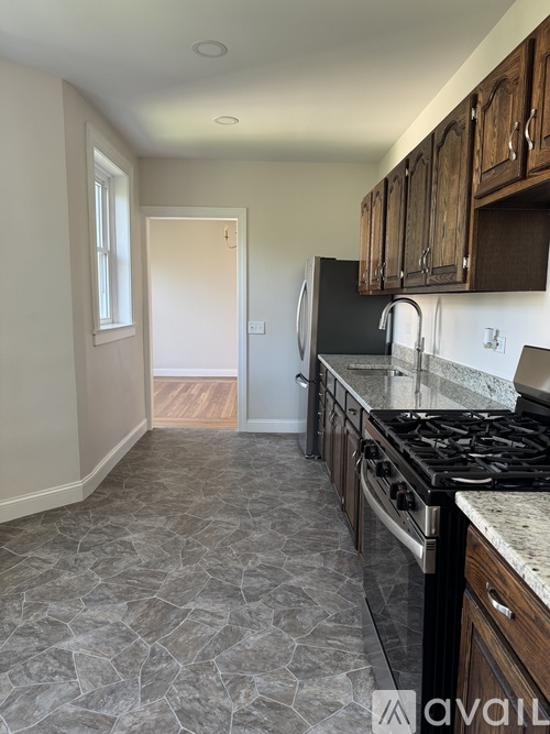 A kitchen with a black stove top oven and wooden cabinets.