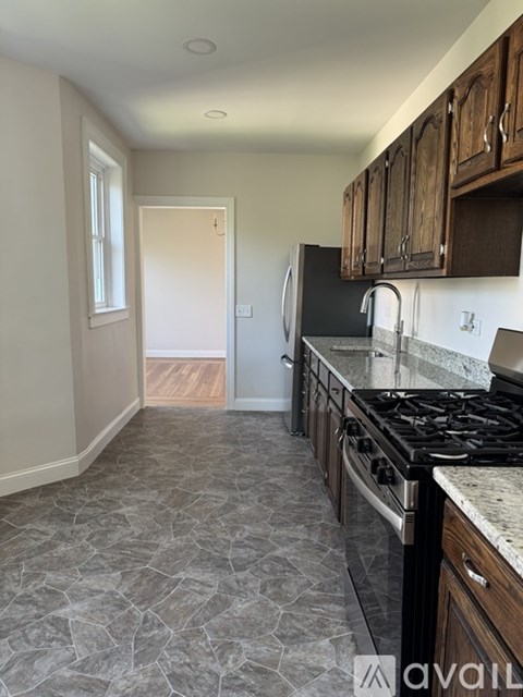 A kitchen with a black stove top oven and wooden cabinets.