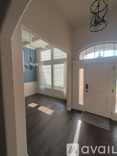 A room with a white door and a chandelier.