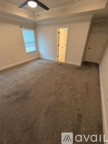 A room with a ceiling fan and carpeted floor.