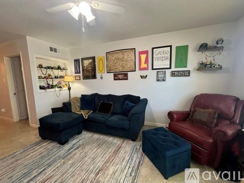A living room with a blue couch, a red chair, and a rug.