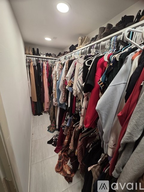 A row of clothes hangs on a rack in a room.