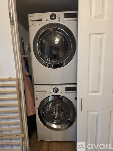 A stacked washer and dryer in a small room.