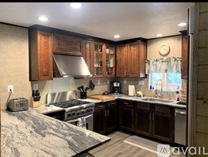 A kitchen with wooden cabinets and a marble countertop.
