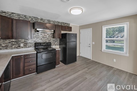 A kitchen with a black refrigerator and stove.