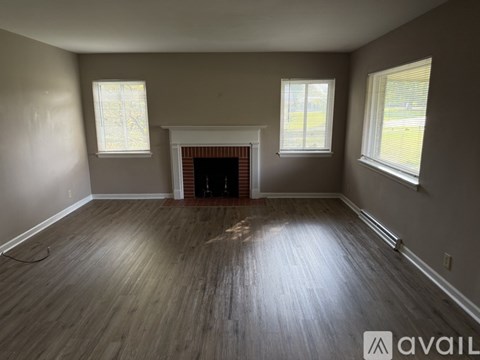 A room with a fireplace and wood flooring.