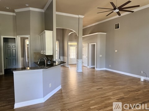 A spacious kitchen with a white counter and a ceiling fan.