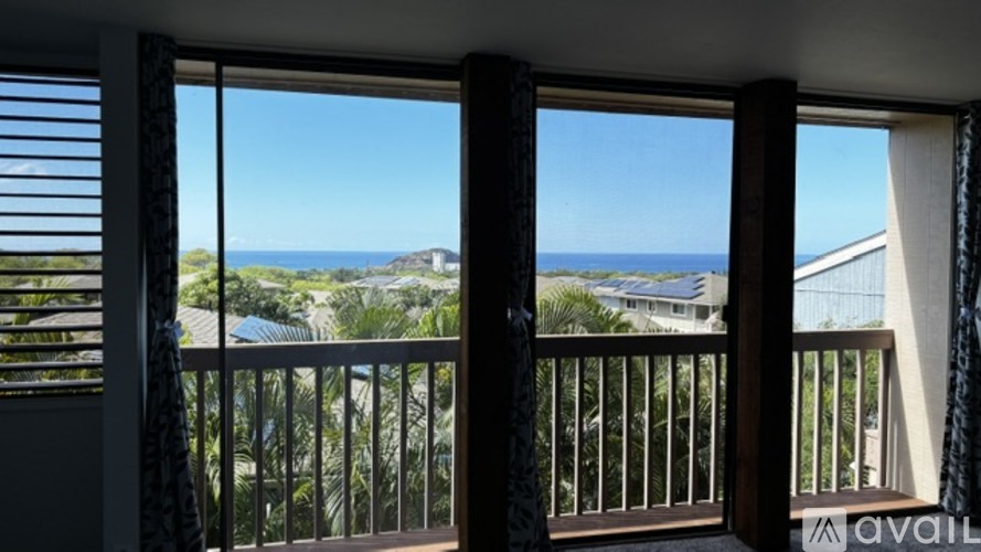A balcony with a view of the ocean and buildings.