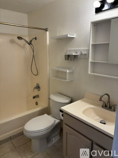 A bathroom with a toilet, sink, and shower.