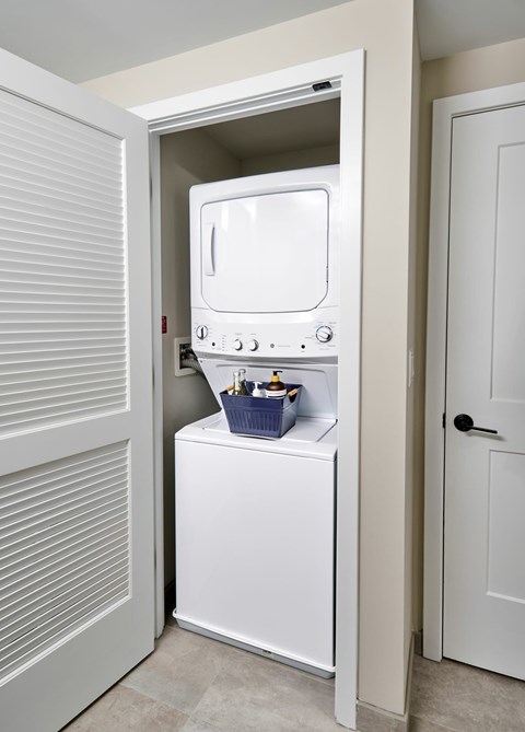 A white oven is built into a kitchen cabinet.