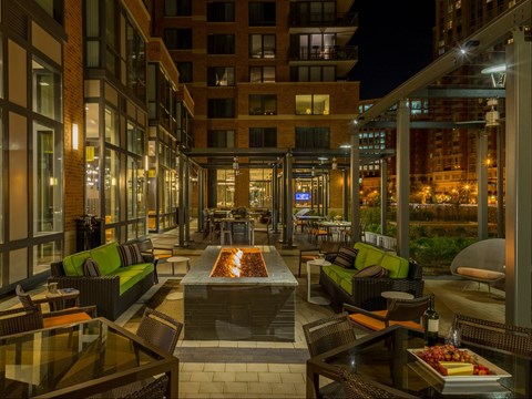 A patio with a table and chairs is surrounded by buildings.
