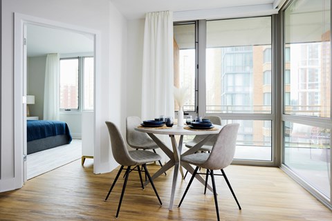 A dining room with a table set for two and a view of the city.