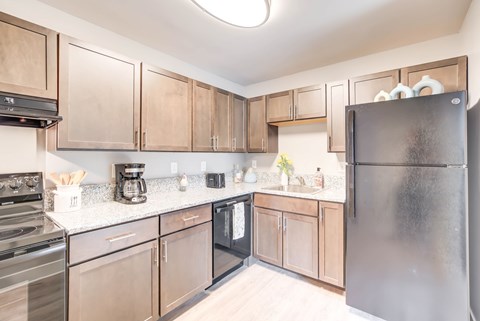 A kitchen with a black oven and a black fridge.