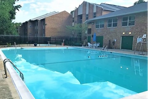A swimming pool in front of a brick building.