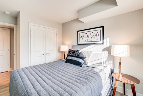 A bedroom with a large bed and a painting above it.