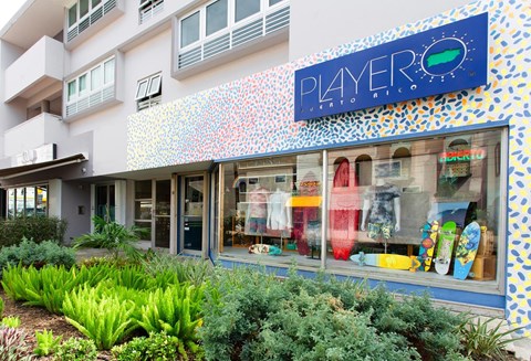 A storefront with a blue sign that says "PLAYERO" above the windows.