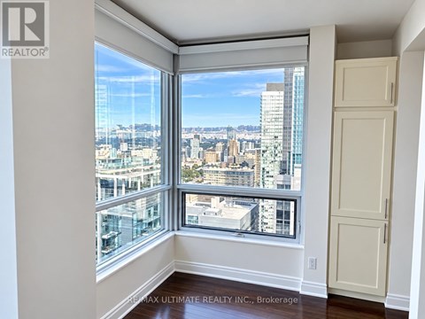 A room with a view of the cityscape through large windows.
