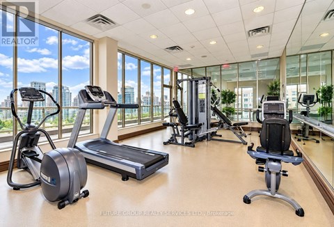 A gym with treadmills, elliptical machines, and a stationary bike.