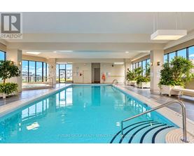 A large indoor swimming pool with a glass wall on one side.
