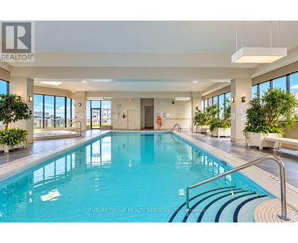 A large indoor swimming pool with a glass wall on one side.