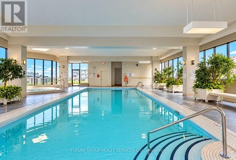 A large indoor swimming pool with a glass wall on one side.