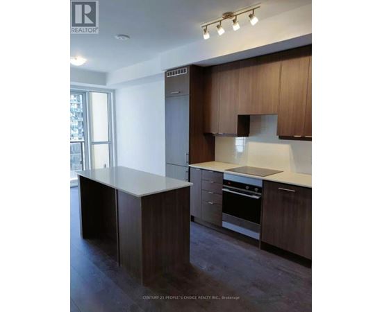 A kitchen with dark wood cabinets and a white countertop.