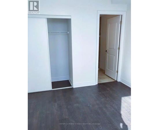 A room with a white door and a white closet with a shelf.