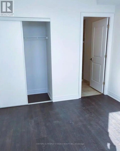 A room with a white door and a white closet with a shelf.