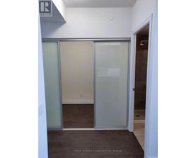 A room with a glass door and a brown floor.