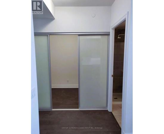 A room with a glass door and a brown floor.