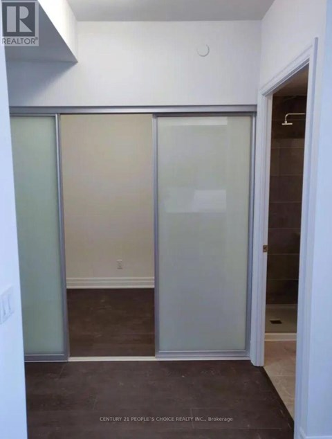 A room with a glass door and a brown floor.