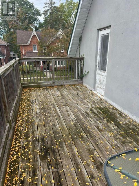 A wooden deck with leaves scattered on it.