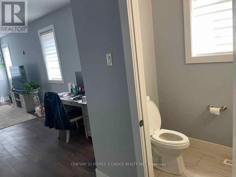 A bathroom with a toilet and a window.