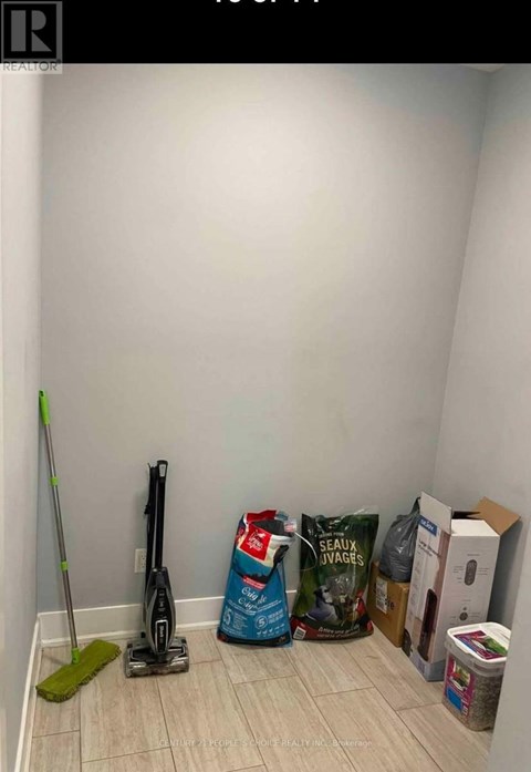 A room with a vacuum cleaner, a mop, and a bag of Seaux Javages.